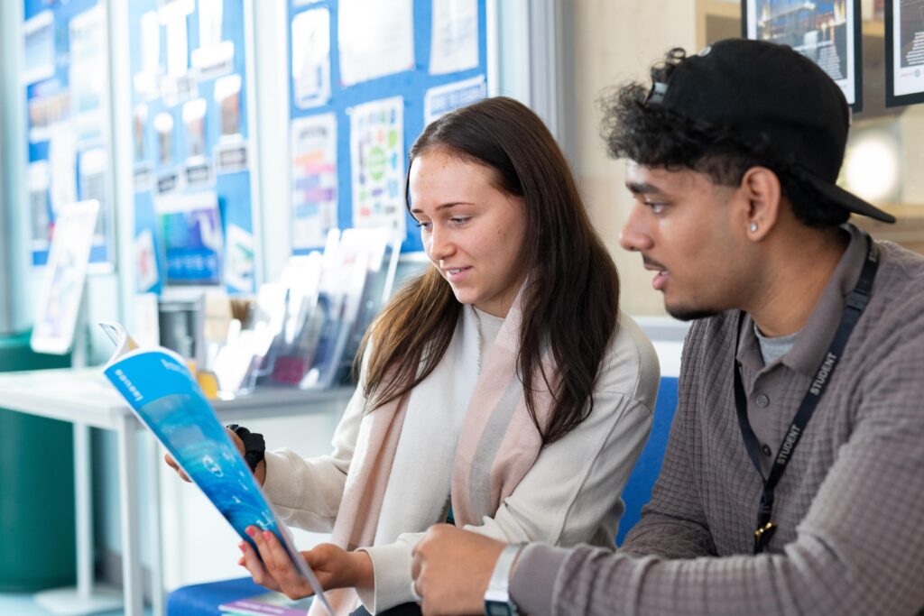 girl and boy student reading together